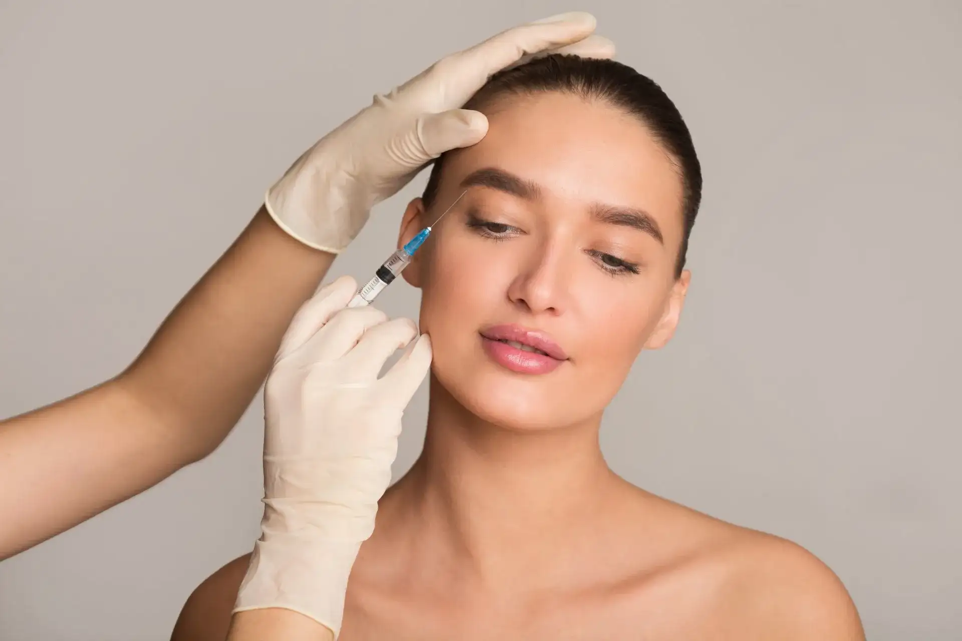 Aesthetic medical professional administering a cosmetic injection to a young woman’s face, highlighting a beauty treatment procedure for skin rejuvenation.